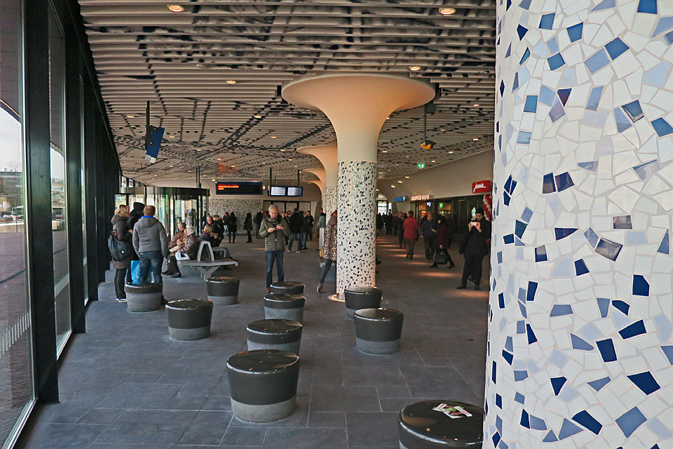 De pilaren zijn bekleed met een mozaïek van Delftsblauwe tegeltjes.