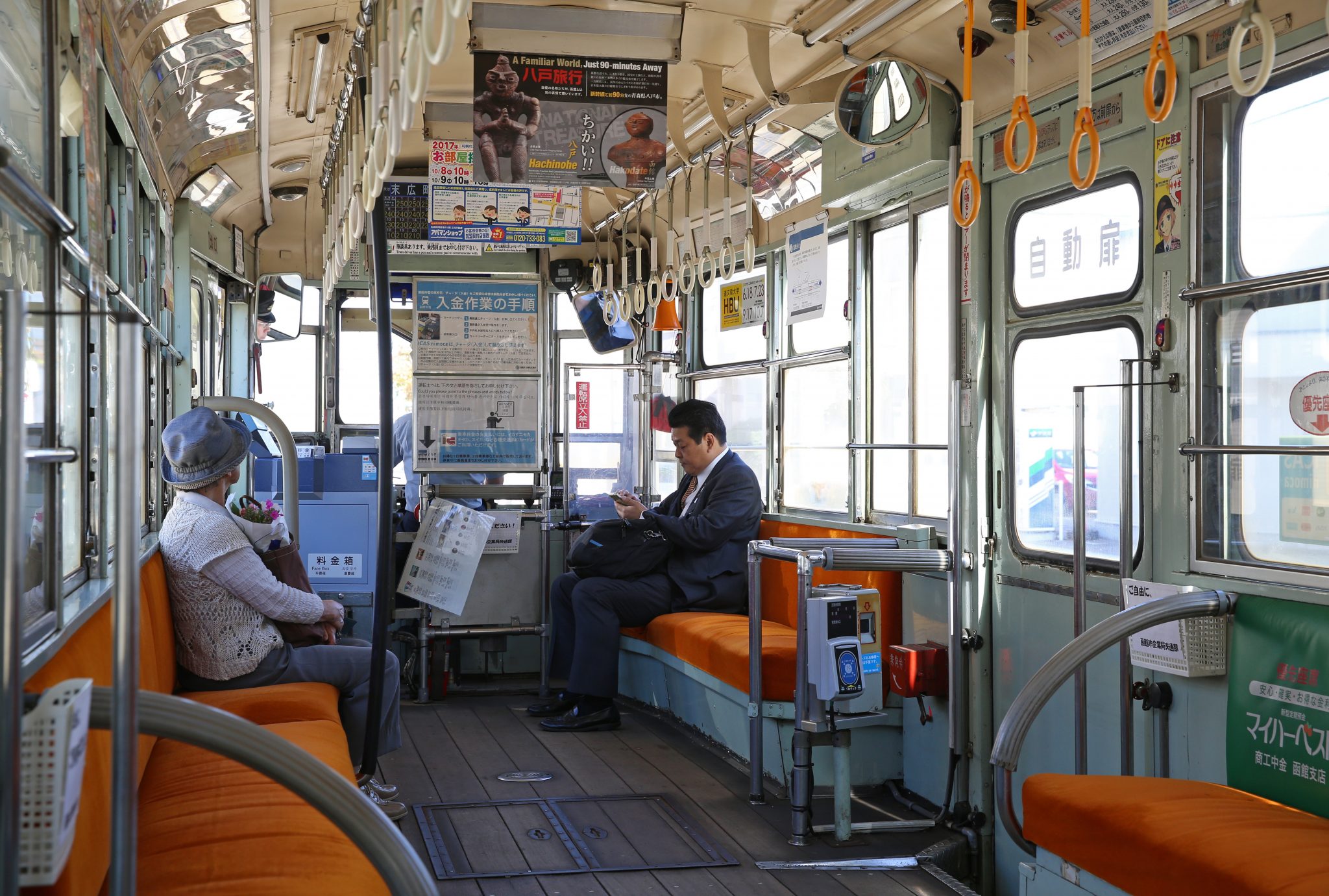 Interieur van een oude tram met langsbanken. 