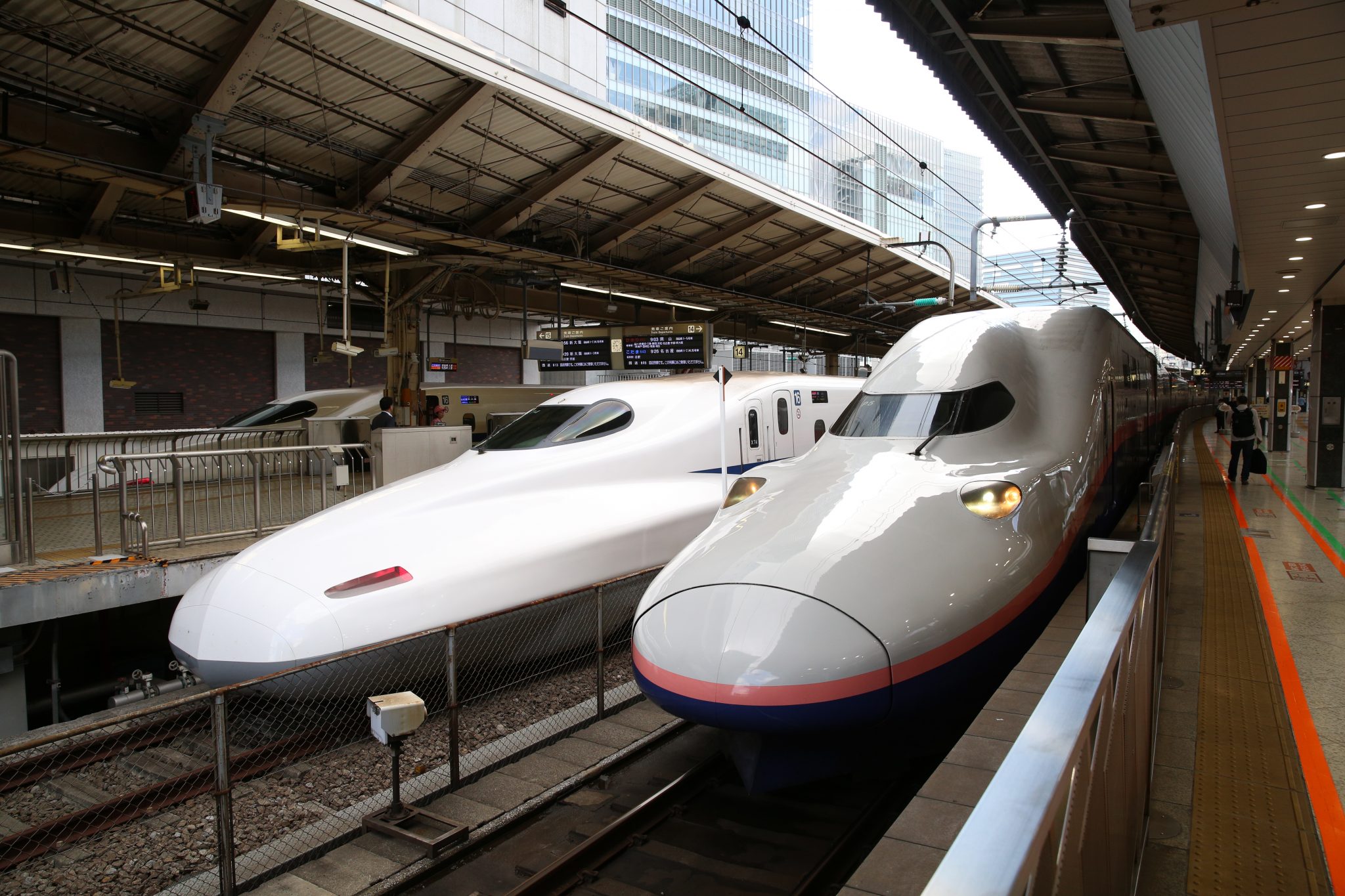 Tokio. Shinkansen van het zuidnet (links) en het noordnet, van elkaar gescheiden door een hek. 