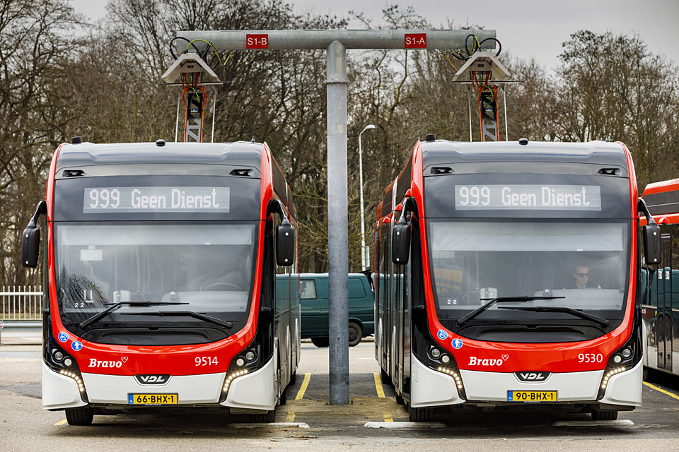 Twee bussen aan de laadpaal op het buitenterrein.