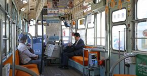 Interieur van een oude tram met langsbanken. 