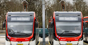 Twee bussen aan de laadpaal op het buitenterrein.