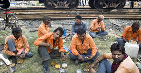 Spoorwegarbeiders lunchen langs de spoorlijn, waar ze aan het werk zijn.