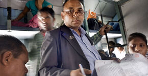 Conducteur controleert de passagierslijst in de trein van Bhopal naar Indore.